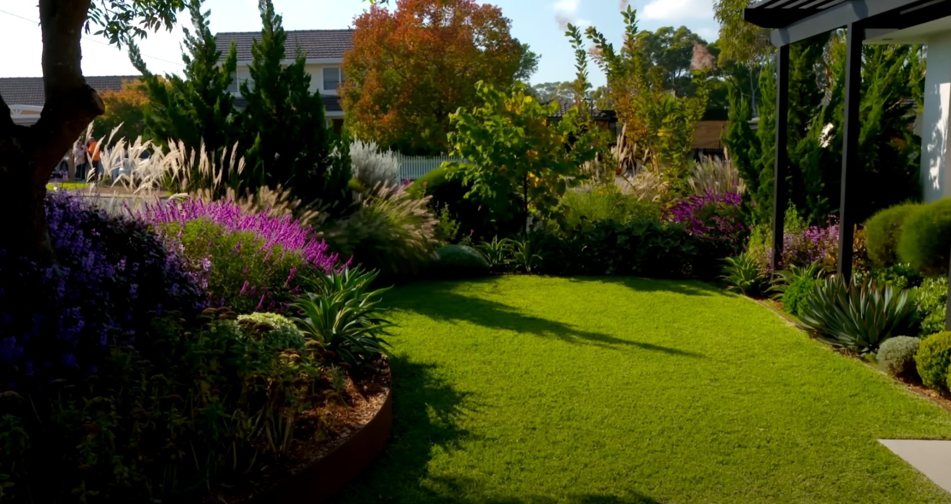Grass Type Selection and Lawn Installation Services Beautifully landscaped backyard with lush green lawn, colorful flower beds, and mature trees