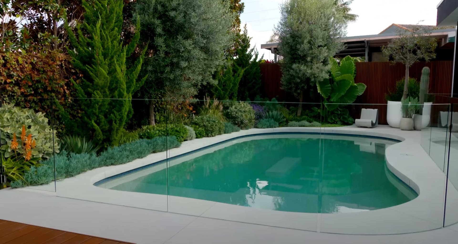 Professional Lawn Mowing and Maintenance Services Modern landscaped backyard with swimming pool, manicured lawn, and professional landscape design