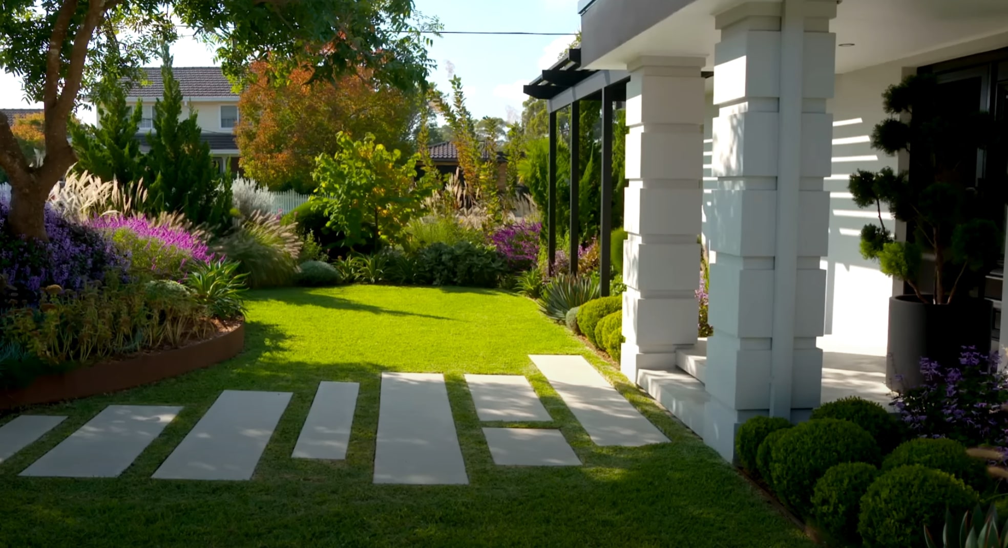 Family-Friendly Landscape Design and Installation Modern front yard with geometric concrete pavers, ornamental grasses, and contemporary landscape design